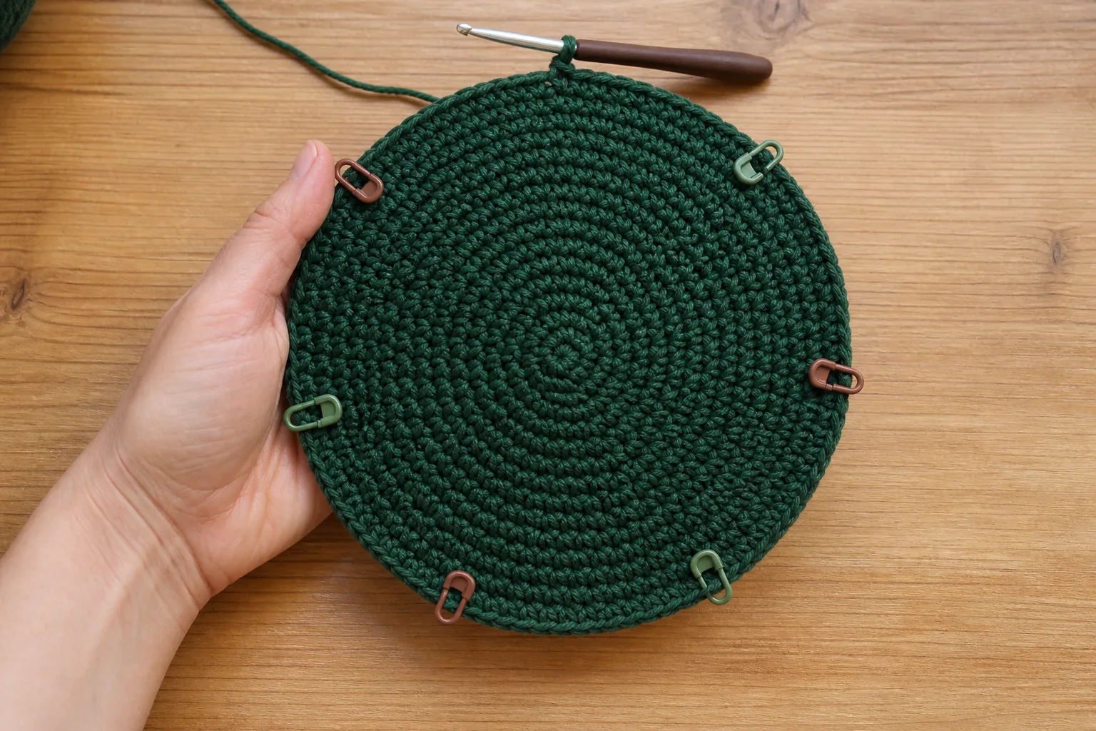 Flat forest-green single crochet crown divided into six stitch-marker sectors