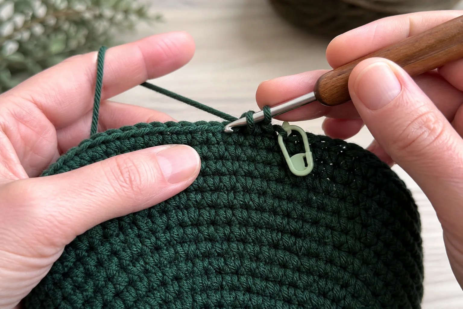Crochet hook entering the next single crochet stitch beside a first-stitch marker