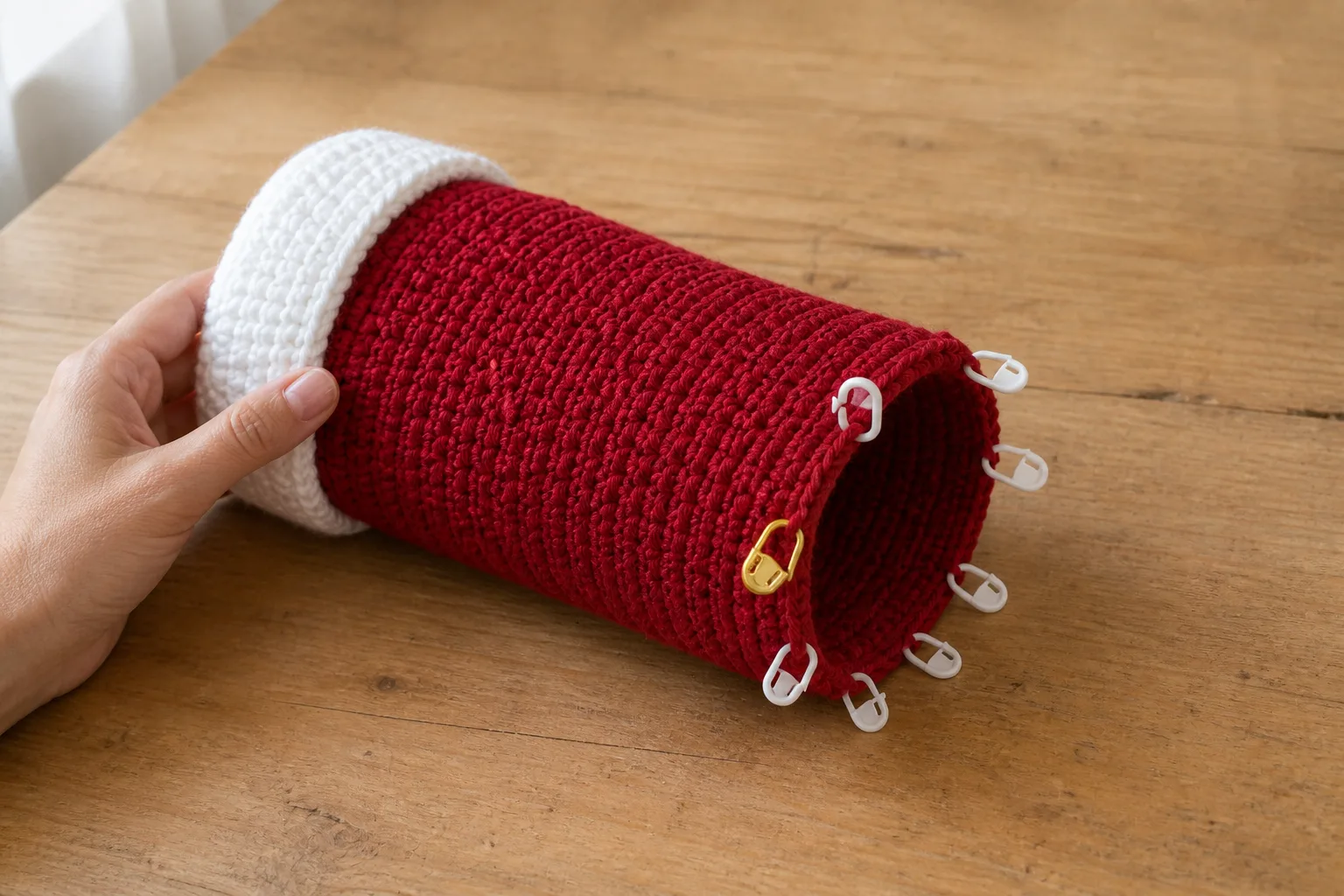 Eight white sector markers and one gold round marker divide a red crochet hat tube