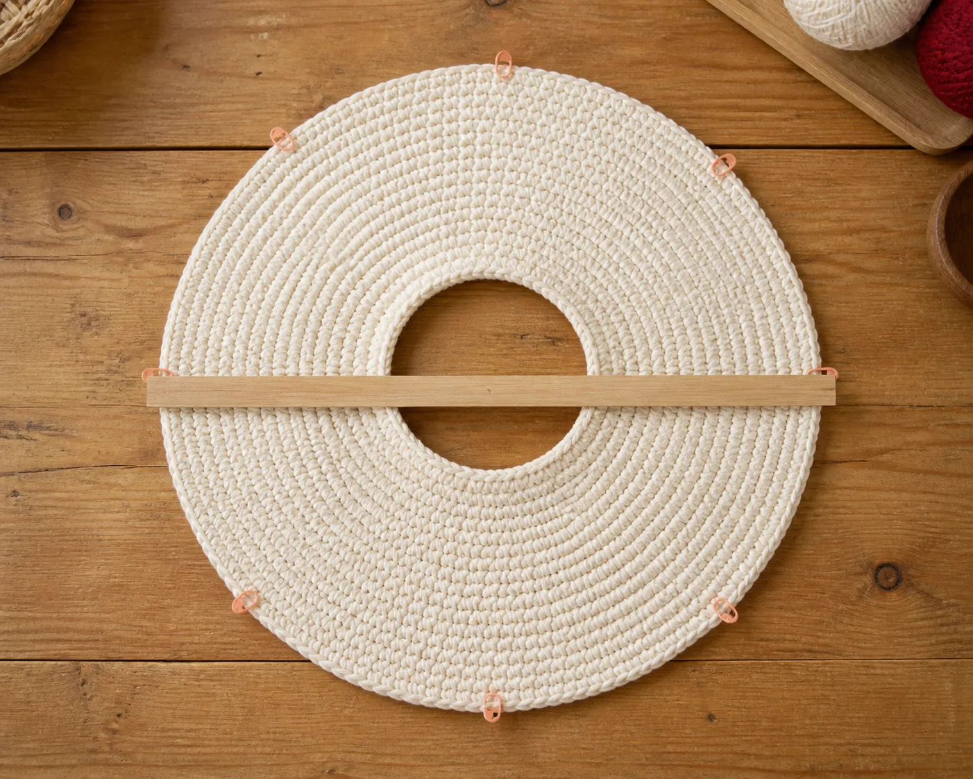 A cream crochet annulus lies flat with eight sector markers and a measured outer diameter